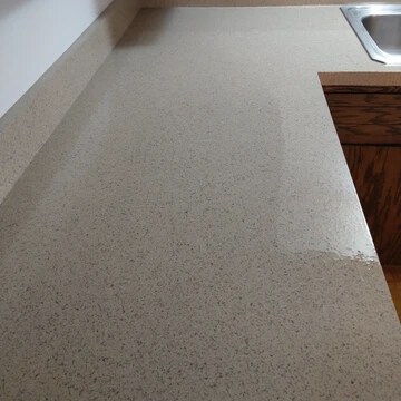 The image shows a countertop with a light brown stone finish.