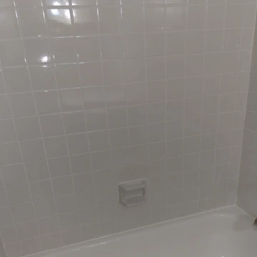 The image shows white refinished tile on the wall of a bathroom.